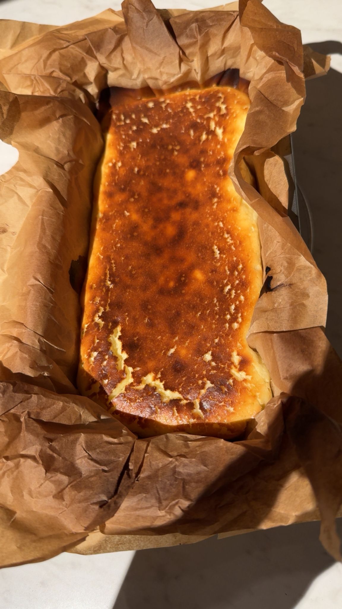 Freshly baked burnt basque cheesecake in parchment paper